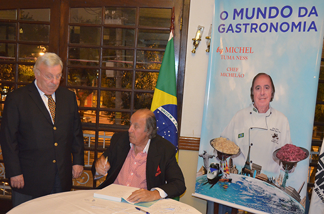 O Professor Mario Carlos Beni, que é presidente da CenTur, aguardando o livro ser autografado pelo Chef Michelão 